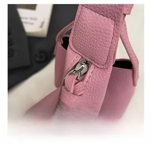 Nahaufnahme einer rosa Handtasche mit Lederstruktur und hochwertigem Silberreißverschluss