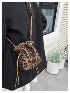 Detail view of leopard print bucket bag with silver chain and velvet texture
