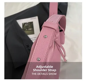 Details des verstellbaren Schultergurts mit Metallnieten an einer rosa Ledertasche