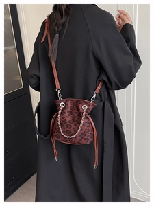 Detail of leopard print bucket bag with drawstring closure and metal chain strap