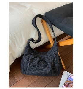Détail du sac hobo en nylon à carreaux gris avec texture à cordon et bandoulière large