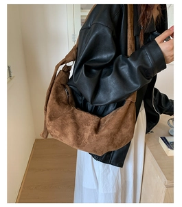 Detailed close-up of brown suede hobo bag with unique knotted strap and zipper
