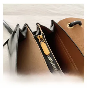 Detailed macro view of high-quality smooth black leather handbag with gold metal zipper