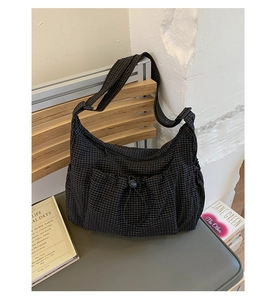 Détail du sac lune en nylon à carreaux noirs avec poche avant à cordon coulissant