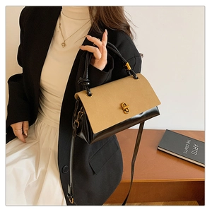Detail showing contrast suede patchwork and gold twist lock on the leather handbag