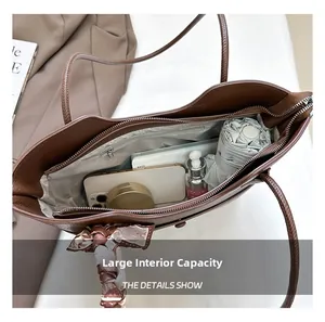Top view of spacious brown tote bag interior with umbrella, makeup, and daily items