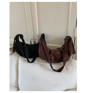 Detail of minimalist suede hobo bag with knotted strap and soft matte texture finish