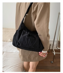 Détail du sac cabas en toile à carreaux noirs avec texture froncée sur un mannequin