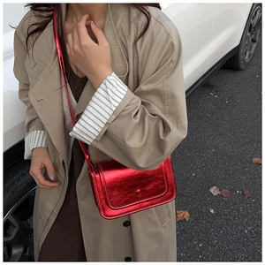 Fashionable red metallic crossbody square bag shown on a model with a khaki trench coat