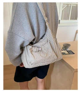 Détail du sac à bandoulière à carreaux avec cordon de serrage et sangle réglable