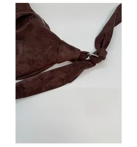 Detail view of the brown suede hobo bag showing the knot shoulder strap and metal hardware