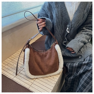 Détail du sac en daim marron avec bordure en fausse fourrure blanche et sangle en cuir