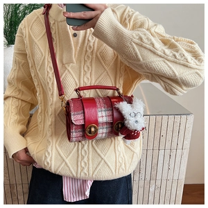 Détail du sac bandoulière à carreaux rouges et blancs avec pendentif chien en peluche mignon