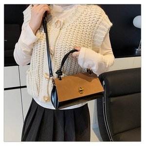 Detail of two-tone crossbody bag with brown suede flap and black leather body with gold lock