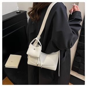 Nahaufnahme der weißen Schultertasche mit Litschi-Muster und kleinem passenden Beutel