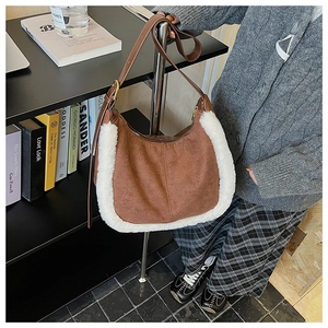 Détail du sac en daim marron avec bordure en laine d'agneau et bandoulière réglable
