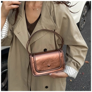 Detail of vintage bronze handbag with metallic crinkle texture and hard round handle