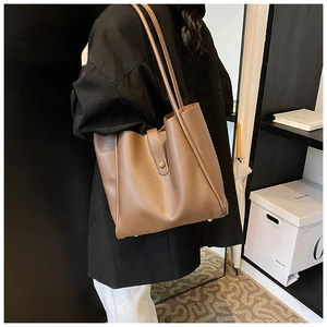 Sac fourre-tout en cuir marron montrant la grande capacité et le détail de la sangle