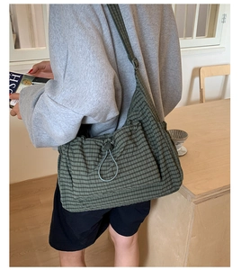 Détail du sac bandoulière en nylon à carreaux vert foncé avec cordons réglables