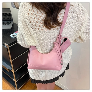 Detaillierte Textur der rosa Handtasche mit Litschi-Maserung und kleinem Anhänger