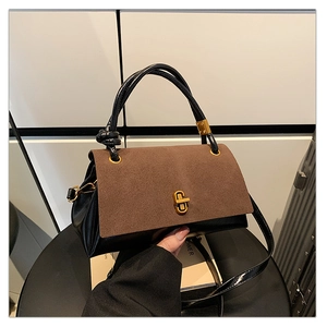 Detail of two-tone leather handbag with suede flap and elegant gold metal clasp closure