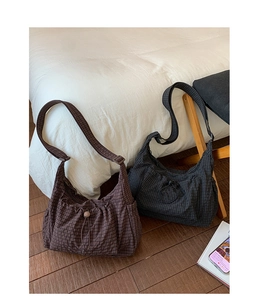 Détail de sacs bandoulière en nylon à carreaux avec cordon et sangle réglable au sol