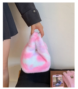 Detail of pink and white plush cow print handbag with soft faux fur texture for winter