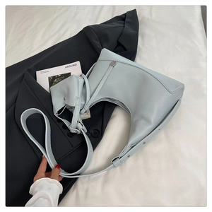 Detail der hellblauen Hobo-Tasche aus Leder mit Litschi-Struktur und passendem Beutel