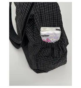 Vue détaillée de la poche latérale à cordon du sac à carreaux avec mouchoirs jetables