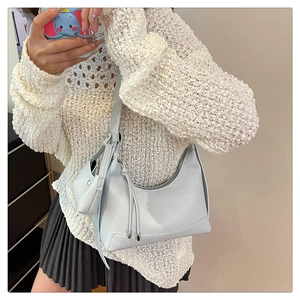 Detail der hellgrauen Hobo-Tasche aus Leder mit Lychee-Muster und Mini-Münzfach