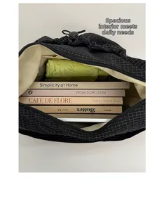 Vue intérieure du sac à carreaux noirs montrant sa grande capacité pour livres et parapluie