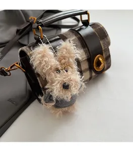 Détail du sac cylindrique rétro à carreaux avec un joli pendentif chiot en peluche