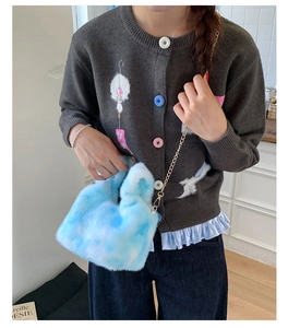 Detail shot of a soft faux rabbit fur crossbody bag in light blue and white tie-dye plush