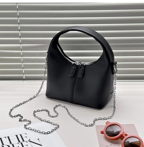 Detail view of black semi-circular crossbody bag with silver chain and dual zipper closure