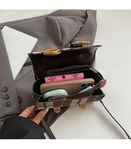 Vue intérieure montrant la grande capacité du sac à bandoulière à carreaux tendance
