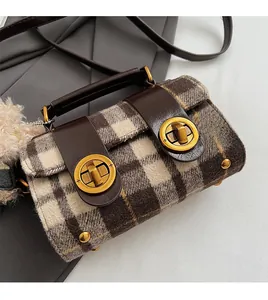 Détail du sac bandoulière en tweed à carreaux avec fermoirs dorés et pompon gris