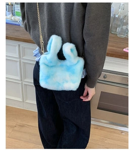 Detail of blue and white plush chain bag showing faux fur texture and gold chain strap