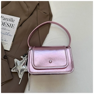 Detail view of metallic pink square bag with star charm and bead clasp closure