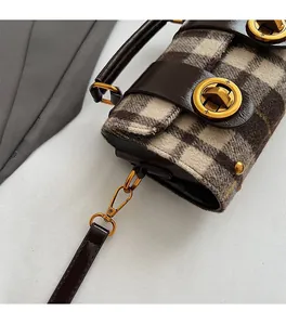 Gros plan détaillé du fermoir doré rotatif et de la texture du tissu en tweed à carreaux