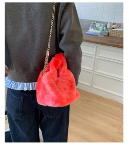 Detail of fluffy plush pink chain bag showing soft faux fur texture and gold metal strap