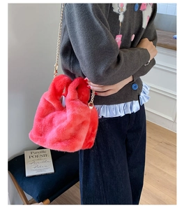 Detail of pink faux fur plush bag with gold metal chain strap for winter style