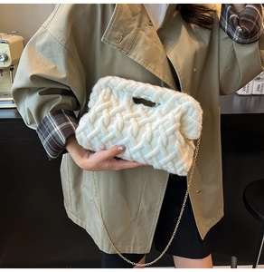 Détail de la texture d'un sac à main blanc en maille épaisse avec chaîne dorée