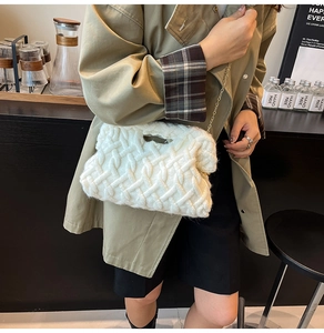 Détail d'un sac en maille fait main crème avec chaîne dorée dans un décor de café