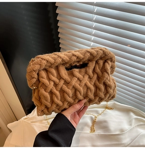 Gros plan sur la texture en maille marron et la chaîne dorée du grand sac à main chic