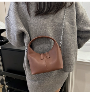 Brown leather hobo handbag with silver metal chain strap styled on gray knit outfit