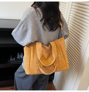 Vue arrière d'un mannequin portant un grand sac cabas jaune gingembre à bandoulière