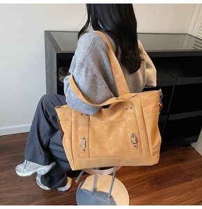 Détail du sac cabas jaune gingembre en daim avec boucles argentées et poches latérales