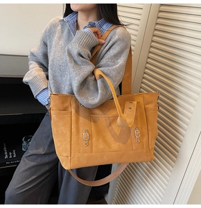 Détail d'un cabas jaune gingembre avec boucle métallique vintage et poches de côté
