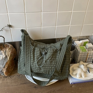 Sac bandoulière en toile à carreaux verts avec poche avant à cordon de serrage