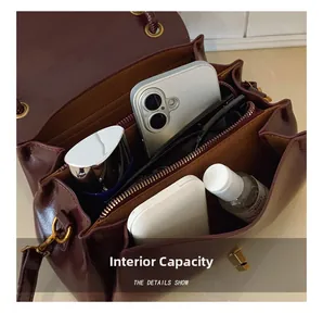 Interior view of wine red shoulder bag showing three compartments and zipper closure